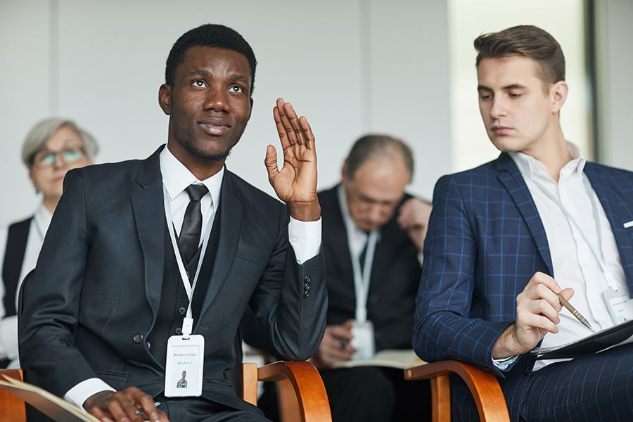 Real estate professional raising his hand at an educational seminar.